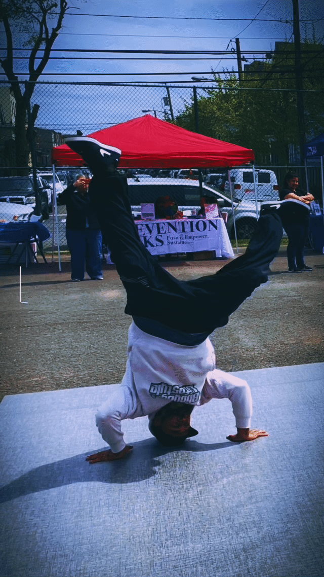 Bboy Rival performing a headspin move demonstrating the physics of breaking